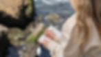A woman sitting on rocks with a journal and, reflecting quietly during recovery.