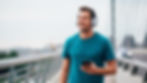 A man walking outdoors with headphones, choosing movement over alcohol during recovery.