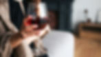 Woman quietly holding a glass of wine, considering whether moderation is possible