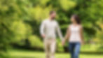 A man walking hand-in-hand with his partner, smiling during early recovery.