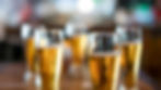 Several pints of beer lined up on a bar, symbolising the temptation to keep drinking after the first.