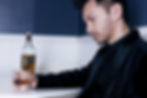 Professional reflecting at night with glass of wine - recognising early signs of relying on alcohol.
