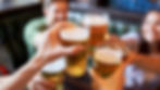 A group of people cheersing with beer in a social setting, representing the challenge of drinking in moderation.