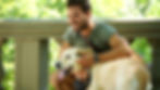 Sober man smiling with his dog outdoors