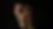 A person crying with eyes closed, holding one hand against their face in a dark setting.