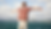 Sober man standing by the ocean with arms outstretched, embracing freedom and clarity during recovery.