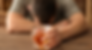 Man showing the long term impacts of alcohol with head down holding glass of alcohol